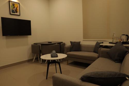 a living room with a couch and a table at Dreamotel Luxury Suites in Kanjikode