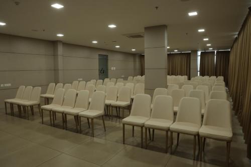 a room with rows of white chairs in it at Dreamotel Luxury Suites in Kanjikode