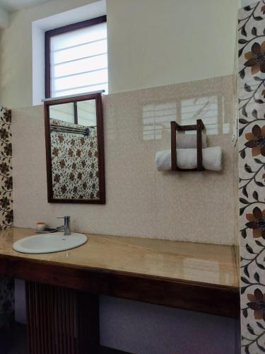 a bathroom with a sink and a mirror and towels at Heritage Home, Hampe's in Mysore