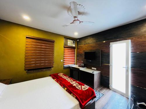 una camera da letto con un letto con una coperta rossa sopra di Hotel Majestic a Calcutta