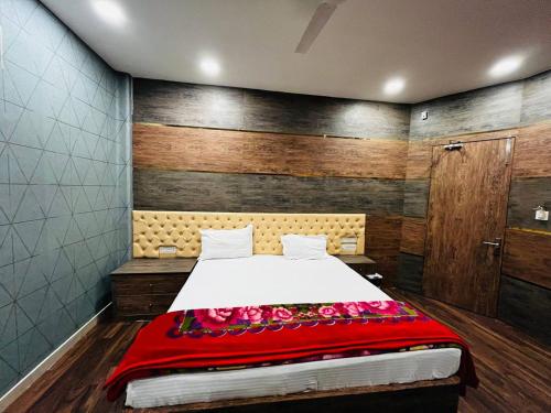 a bedroom with a bed with a red blanket at Hotel Majestic in Kolkata