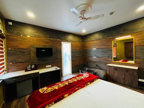a bedroom with a bed with a red blanket at Hotel Majestic in Kolkata
