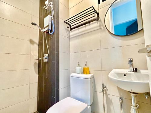 a bathroom with a toilet and a sink and a mirror at Comfort Place 1-7 Pax 3 bedroom Ara Damansara in Petaling Jaya