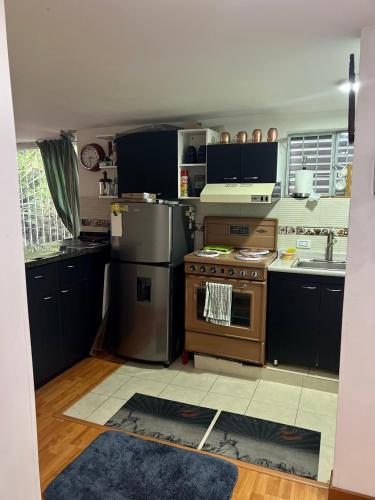 une cuisine avec une cuisinière et un évier dans l'établissement Cousy 2BR Condo in Virrey Walking distance to Andino & Parque 93, à Bogotá