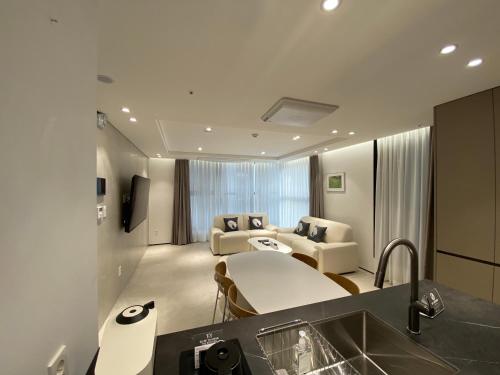 cocina y sala de estar con sofá y lavamanos en HOTEL THE DESIGNERS LYJ SUITE YEOKSAM en Seúl