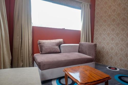 a living room with a couch and a table at RedDoorz Syariah near Gerbang Dieng 2 in Dieng