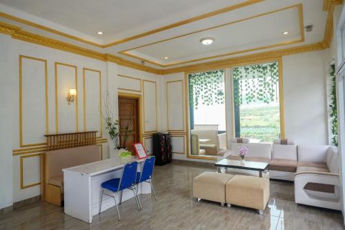 a living room with a couch and a table and chairs at RedDoorz Syariah near Gerbang Dieng 2 in Dieng