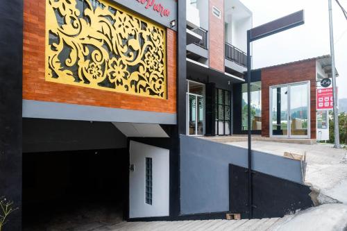 a building with a yellow sign on the side of it at RedDoorz Syariah near Gerbang Dieng 2 in Dieng