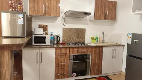 a kitchen with a refrigerator microwave and a stove at BaliApartments in Grand-Baie