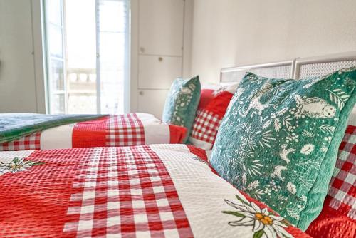 1 dormitorio con 2 camas y edredón rojo y blanco en Sweet Room by Interlaken en Därligen