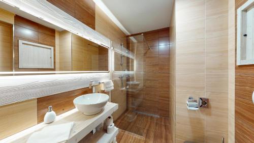 a bathroom with a sink and a mirror at Grand Apartments Hrebienok in Smokovce
