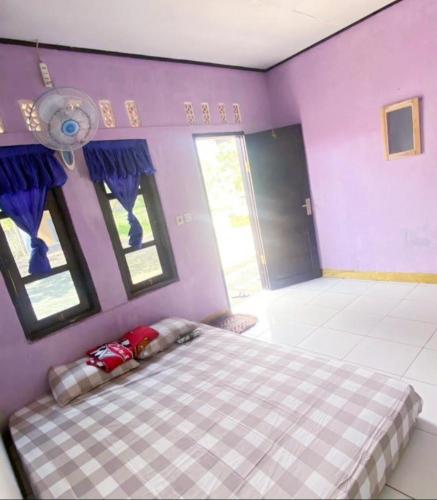 a bedroom with a bed in a purple room at Penginapan & Homestay Geopark Ciletuh in Cikadal