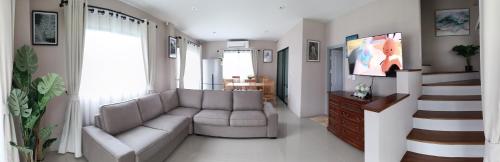 un soggiorno con un divano e una TV di 88house suratthani a Suratthani