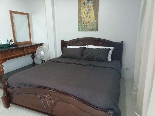 a bedroom with a bed with a desk and a mirror at 88house suratthani in Surat Thani