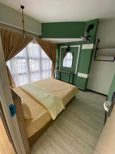 a bedroom with a bed and a large window at Clock Inn Backpackers Hostel in Tanah Rata