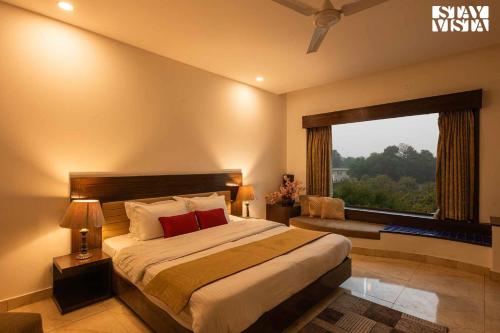 - une chambre avec un grand lit et une fenêtre dans l'établissement StayVista's Casba Farm Retreat - Pet-Friendly Villa with Rooftop Lounge, Outdoor Pool, Lawn & Bar, à Chandigarh
