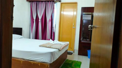- une chambre avec un lit et un rideau rouge dans l'établissement World Beach Resort, à Kelātali
