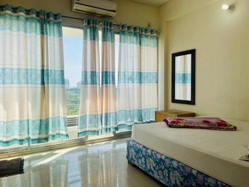 a bedroom with a bed and a large window at World Beach Resort in Kelātali