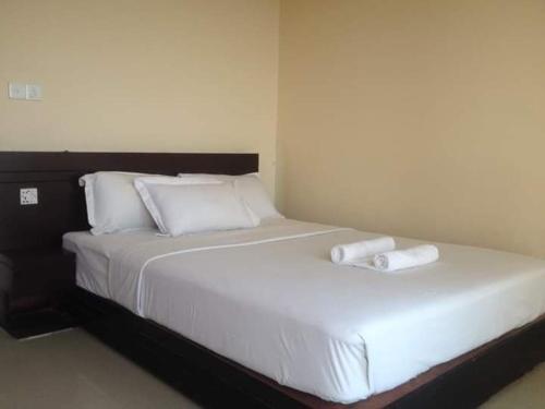 a large white bed with two towels on it at World Beach Resort in Kelātali