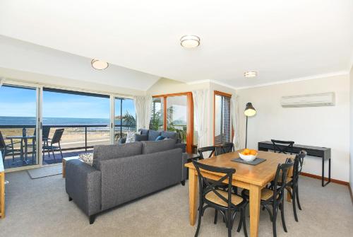 a living room with a table and a couch at Granite Views Beachfront Apartment + WiFi in Encounter Bay