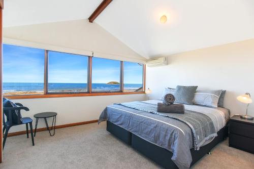a bedroom with a bed with a view of the ocean at Granite Views Beachfront Apartment + WiFi in Encounter Bay