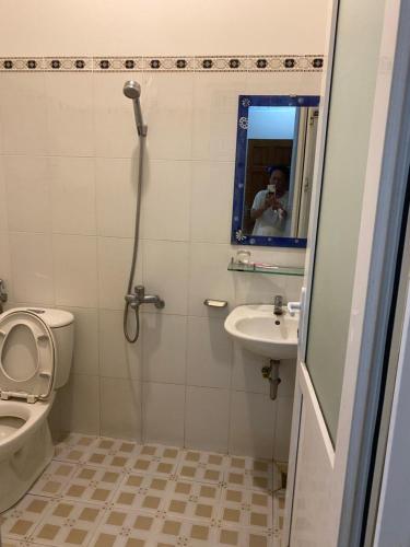 a bathroom with a shower and a toilet and a sink at Nhà Nghỉ 529 in Vung Tau