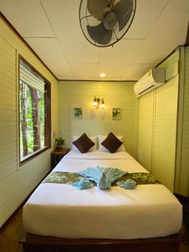 a bedroom with two beds and a fan at Khao Sok Nature Resort in Khao Sok National Park