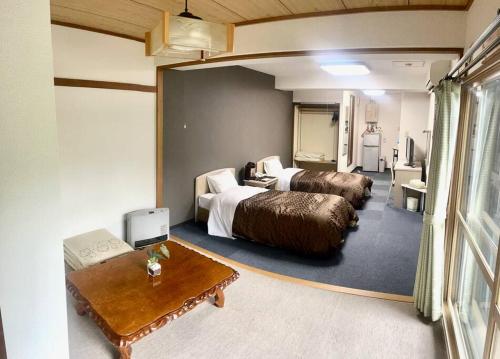 Habitación de hotel con 2 camas y mesa en フューデイズコンドミニアム定山渓211号室(最大5名まで）, en Jozankei