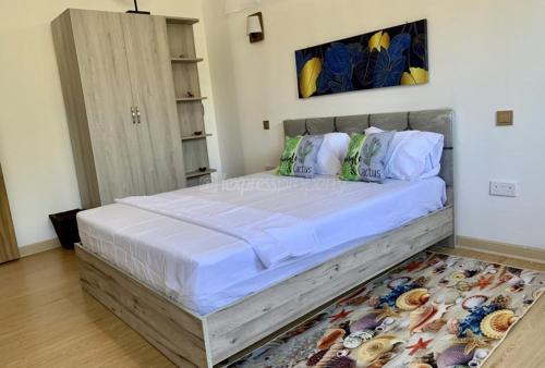 a bedroom with a large bed with white sheets and pillows at BaliApartments in Grand-Baie
