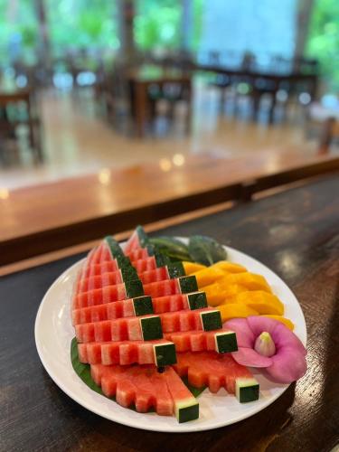 einen Teller geschnittener Früchte auf einem Tisch in der Unterkunft Khao Sok Nature Resort in Khao Sok