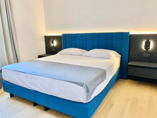 a large bed with a blue headboard in a bedroom at Domo Apuliae Aparthotel in Bari