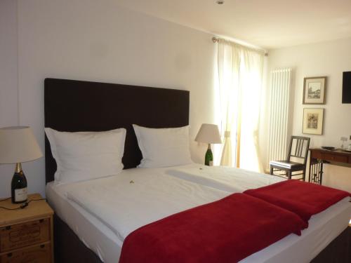 een slaapkamer met een groot bed met een rode deken erop bij Landgasthof Zum Hasen in Kleinwallstadt