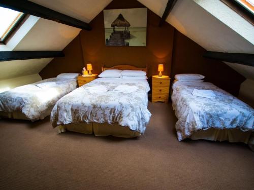 a room with three beds in a attic at The Station Hotel Penrith in Penrith