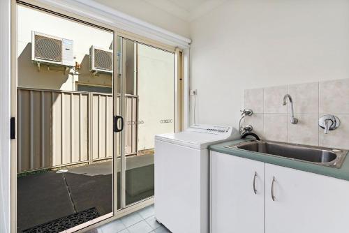 a kitchen with a sink and a dishwasher at Esplanade Beachfront Victor Harbor in Victor Harbor