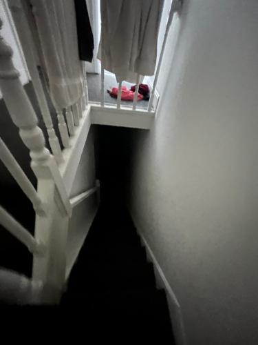 einen Flur mit einer Treppe mit Fenster und Schuhen in der Unterkunft 241 albert avenue in Hull