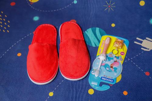 a pair of red slippers and a toy on a table at Jin Jiang Tower in Shanghai