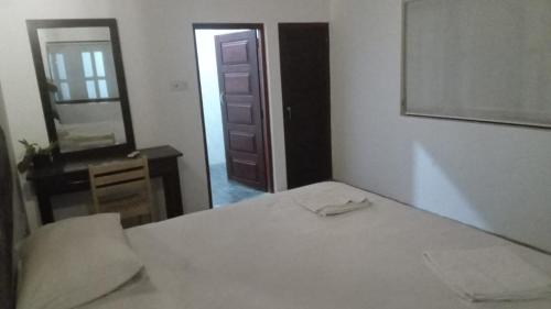 a bedroom with a bed and a mirror and a door at Arugambay PodBay in Arugam Bay