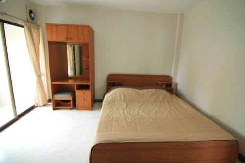 a bedroom with a bed and a dresser in it at Manoo House H in Makkasan