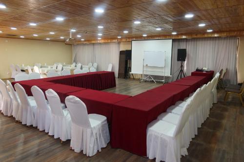 uma sala de conferências com mesas e cadeiras vermelhas e brancas em Sultan Kyzyl-Kia 