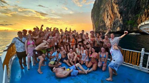 a group of people posing for a picture on a boat at Blanco Beach Bar Hostel in Phi Phi Don
