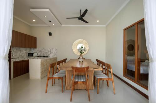 a dining room with a wooden table and chairs at Daha Mansions Seminyak in Seminyak