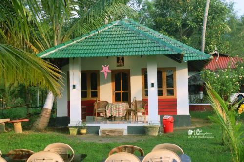 a small house with a green roof at Lake Homes in Varkala