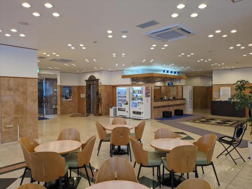 uma cafetaria com mesas e cadeiras e uma cozinha em Toyoko Inn Hokkaido Hakodate Ekimae Daimon em Hakodate