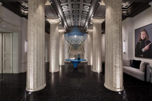 un pasillo con columnas y una escalera en un edificio en Dorothea Hotel, Budapest, Autograph Collection, en Budapest