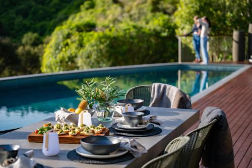 a table with food on it next to a pool at Okoro Villa in Nelson