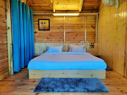 - une chambre avec un lit dans une pièce en bois dans l'établissement Mid Conifer Resort and Cottages, à Dalhousie