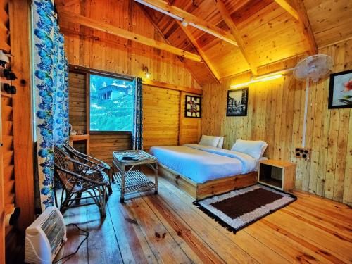 - une chambre avec un lit dans une cabane en bois dans l'établissement Mid Conifer Resort and Cottages, à Dalhousie