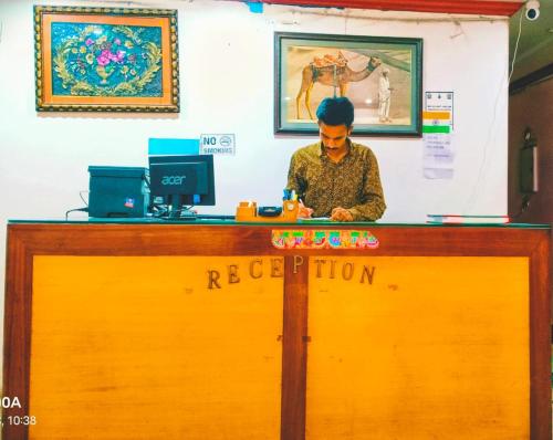 a man sitting at a reception desk with at HOTEL GREEN PALACE in New Delhi