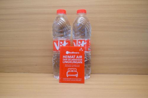 two bottles of water sitting on a wooden table at RedDoorz Apartment near Exit Toll Colomadu in Solo