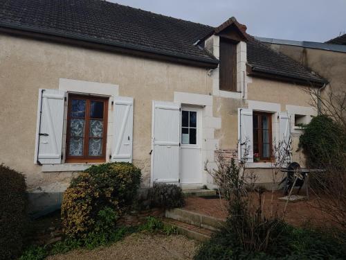Una casa con persianas blancas a un lado. en Gite Anne-Marie Davaillon, en Châtillon-sur-Indre